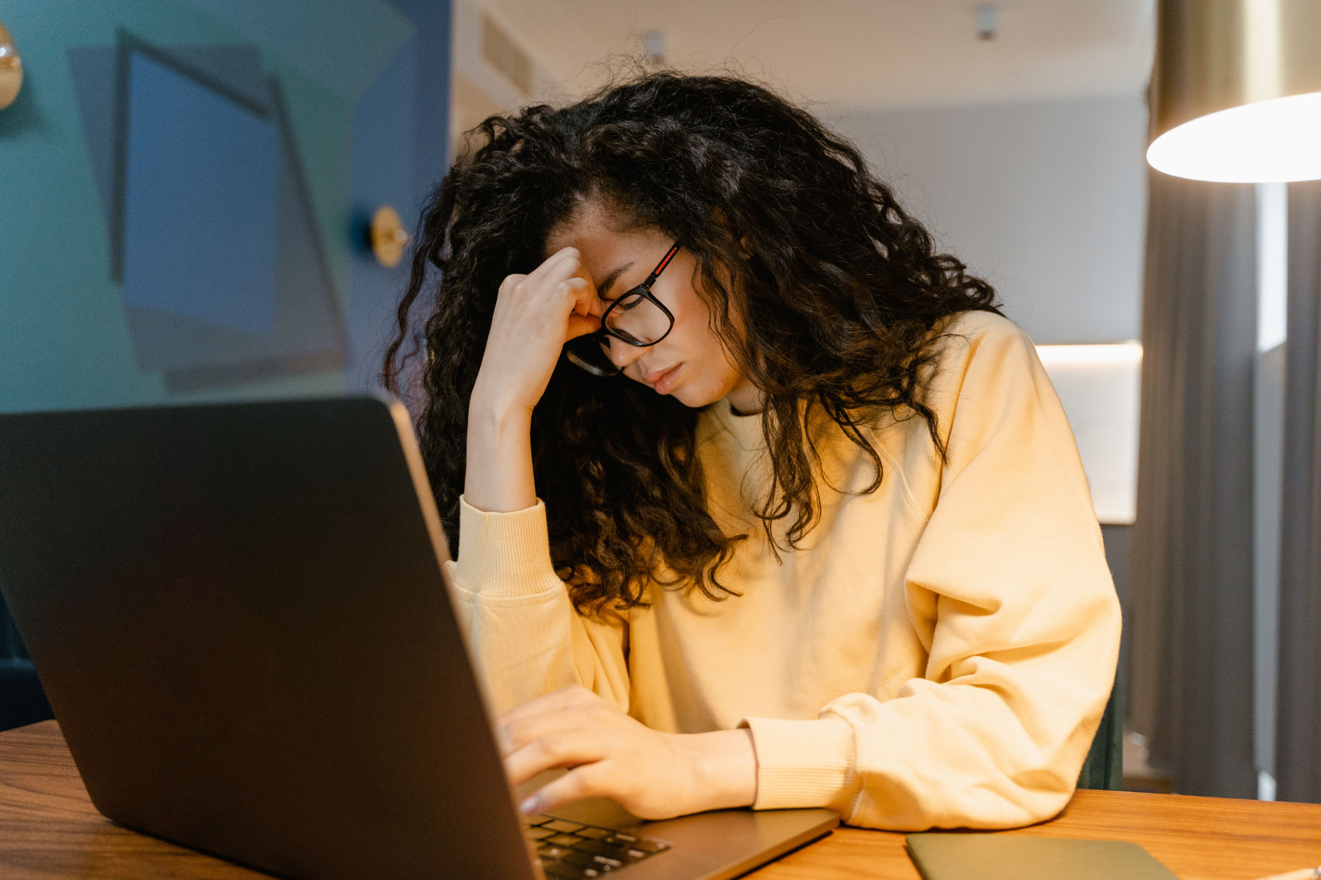 Woman working late at a laptop, feeling drained after work